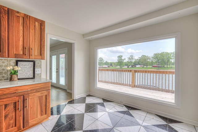 411 Willow Lake Dr, Portland, TN 37148 - kitchen featuring brown cabinetry, granite finish floor, baseboards, light stone counters, and a water view
