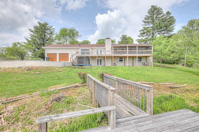 411 Willow Lake Dr, Portland, TN 37148 - back of property with a chimney, a trampoline, a yard, and a deck