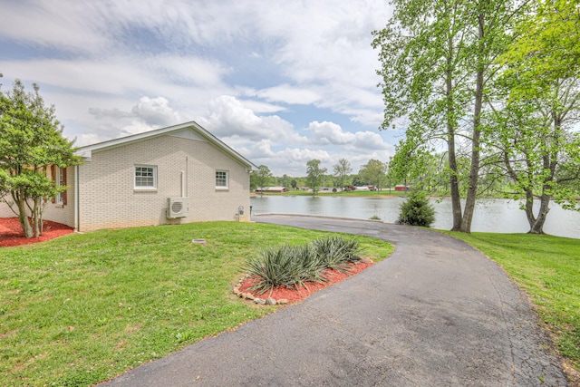 411 Willow Lake Dr, Portland, TN 37148 - view of property exterior featuring aphalt driveway, brick siding, a lawn, a water view, and ac unit
