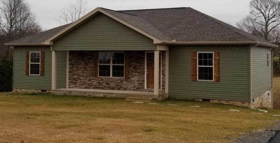view of front of home featuring roof with shingles, a front yard, and crawl space