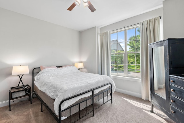 carpeted bedroom featuring baseboards and ceiling fan