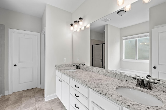 bathroom with a sink, baseboards, a stall shower, and double vanity