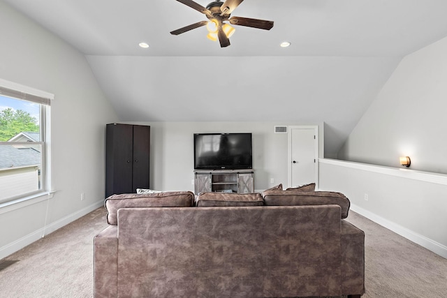 carpeted living room with a ceiling fan, baseboards, vaulted ceiling, and visible vents