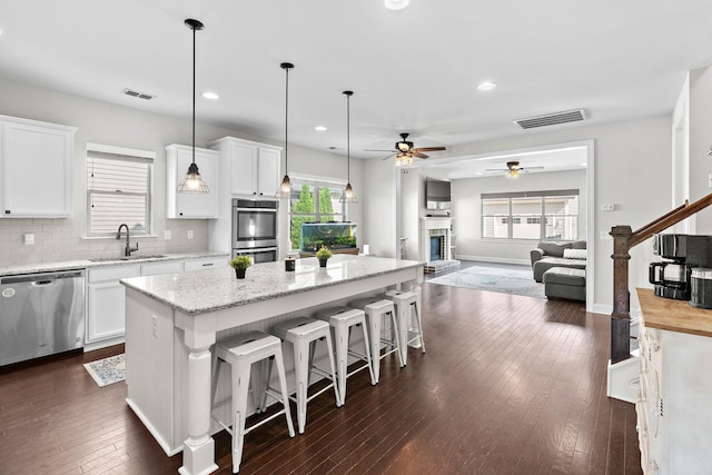 kitchen featuring visible vents, a sink, ceiling fan, and stainless steel appliances