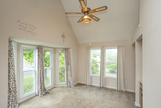 empty room featuring high vaulted ceiling, a ceiling fan, carpet, and baseboards