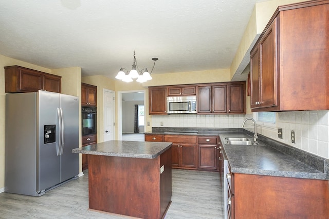 kitchen with black appliances, dark countertops, light wood-type flooring, a sink, and a chandelier