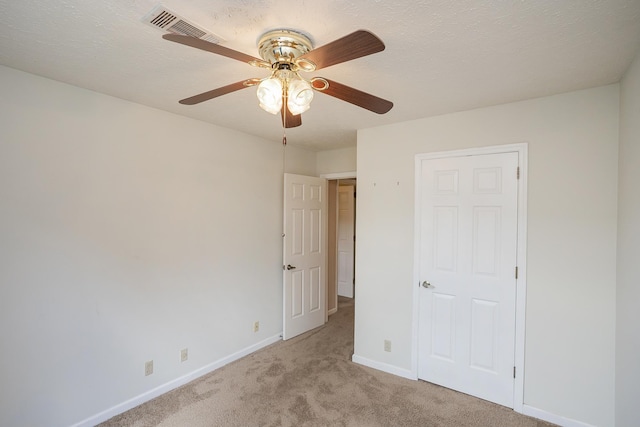 unfurnished bedroom with light carpet, baseboards, and a ceiling fan