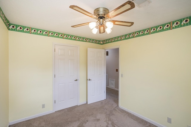 unfurnished bedroom with carpet floors, baseboards, and a ceiling fan