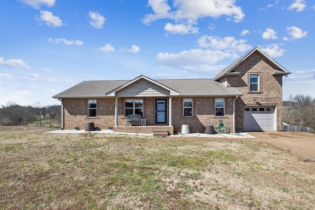 view of front facade featuring brick siding, driveway, a front lawn, and a garage