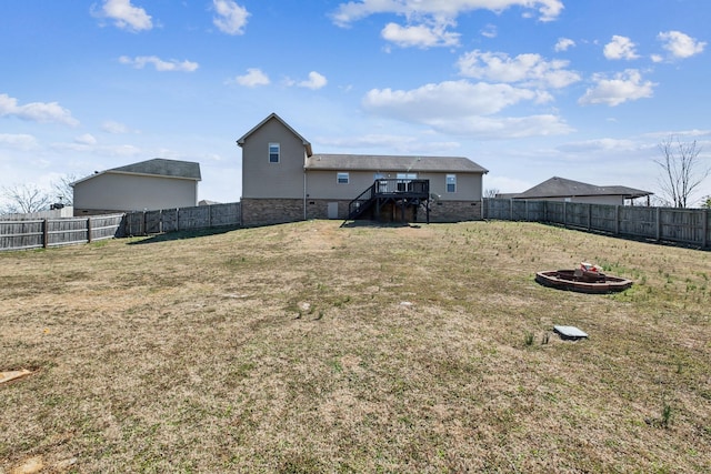 view of yard with a wooden deck, stairs, and a fenced backyard