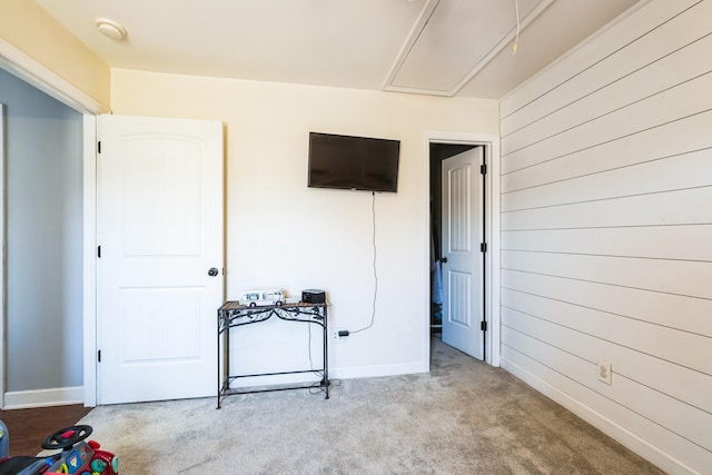 interior space with baseboards, attic access, and wood walls