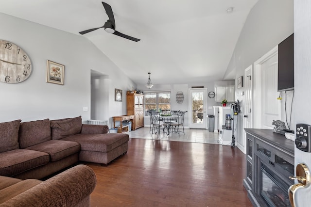 living room with wood finished floors, a ceiling fan, and lofted ceiling