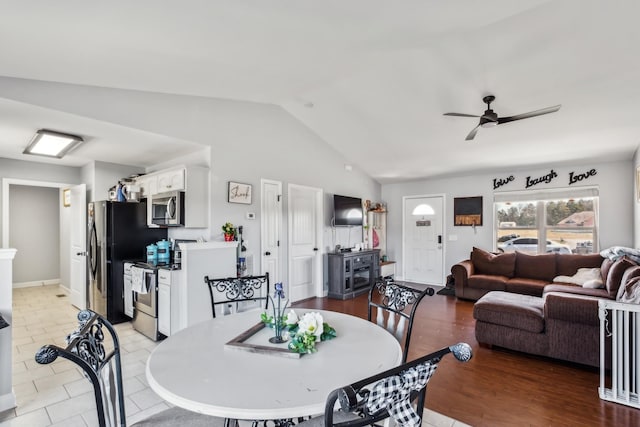 dining area featuring baseboards, ceiling fan, and lofted ceiling