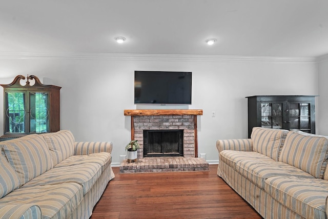 living area with a brick fireplace, baseboards, ornamental molding, and wood finished floors