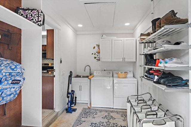 laundry room with cabinet space, a sink, attic access, recessed lighting, and washing machine and dryer