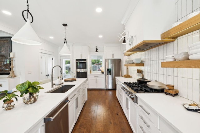 kitchen with a sink, backsplash, white cabinets, and stainless steel appliances