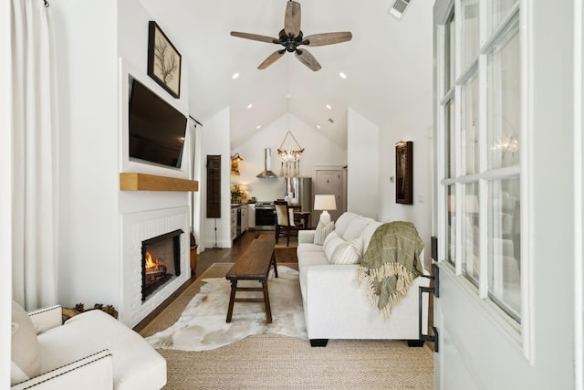 living room with ceiling fan, visible vents, a brick fireplace, lofted ceiling, and recessed lighting