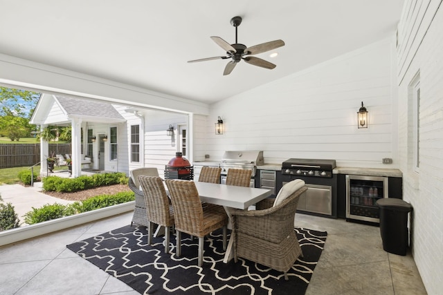 dining room with ceiling fan, a wealth of natural light, beverage cooler, and lofted ceiling
