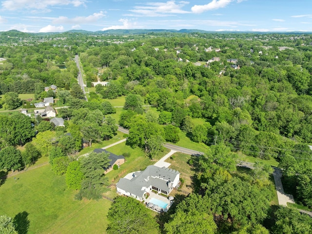 drone / aerial view with a wooded view