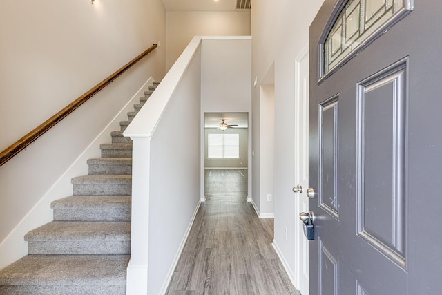 entrance foyer featuring stairs, baseboards, and wood finished floors