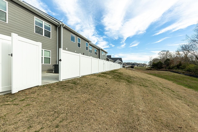 view of yard with central AC unit, fence, and a residential view