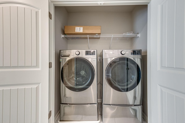 clothes washing area featuring laundry area and washer and clothes dryer