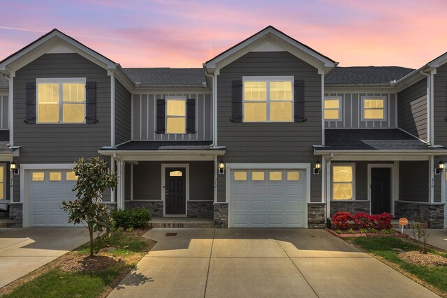 312 Mattie Ln, Spring Hill, TN 37174 - townhome / multi-family property featuring covered porch, concrete driveway, an attached garage, and stone siding