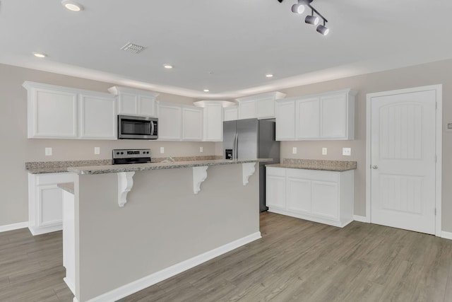 312 Mattie Ln, Spring Hill, TN 37174 - kitchen featuring stainless steel appliances, a breakfast bar, white cabinets, light wood-style floors, and a kitchen island