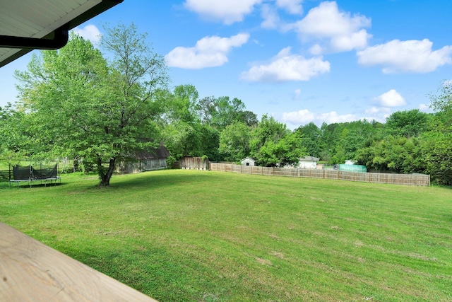 view of yard featuring fence and a trampoline