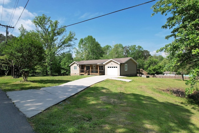 ranch-style home featuring fence, a garage, driveway, and a front lawn
