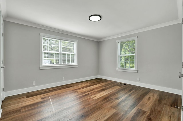 spare room with baseboards, visible vents, ornamental molding, and wood finished floors