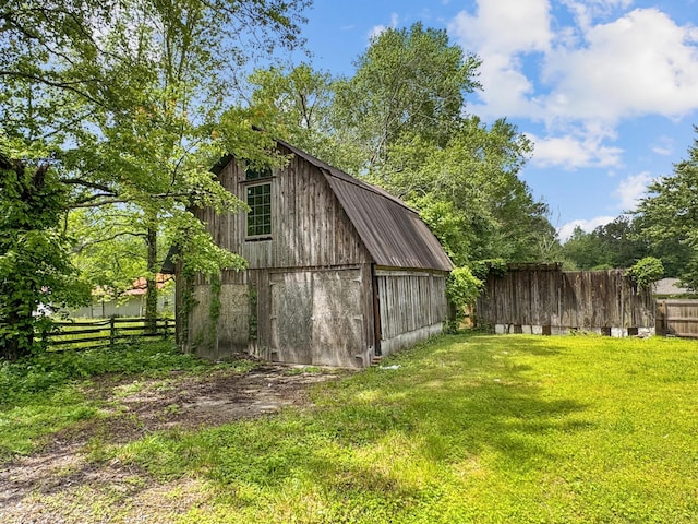 view of barn with a yard and fence private yard