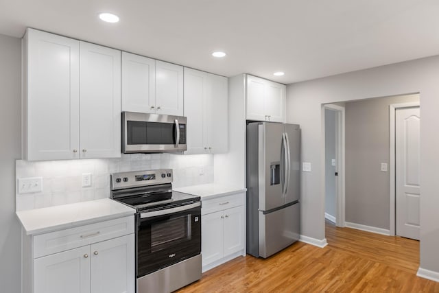1025 Goshentown Rd, Hendersonville, TN 37075 - kitchen with stainless steel appliances, light wood finished floors, decorative backsplash, baseboards, and white cabinets