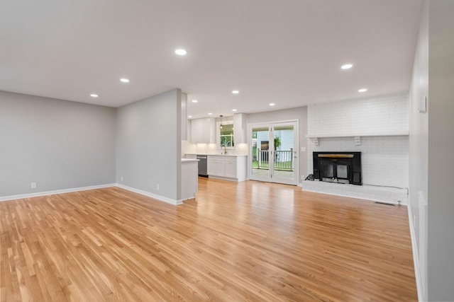 1025 Goshentown Rd, Hendersonville, TN 37075 - unfurnished living room featuring light wood-style flooring, baseboards, recessed lighting, a sink, and a fireplace