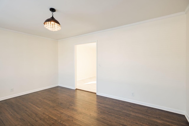 spare room featuring baseboards, dark wood finished floors, and ornamental molding