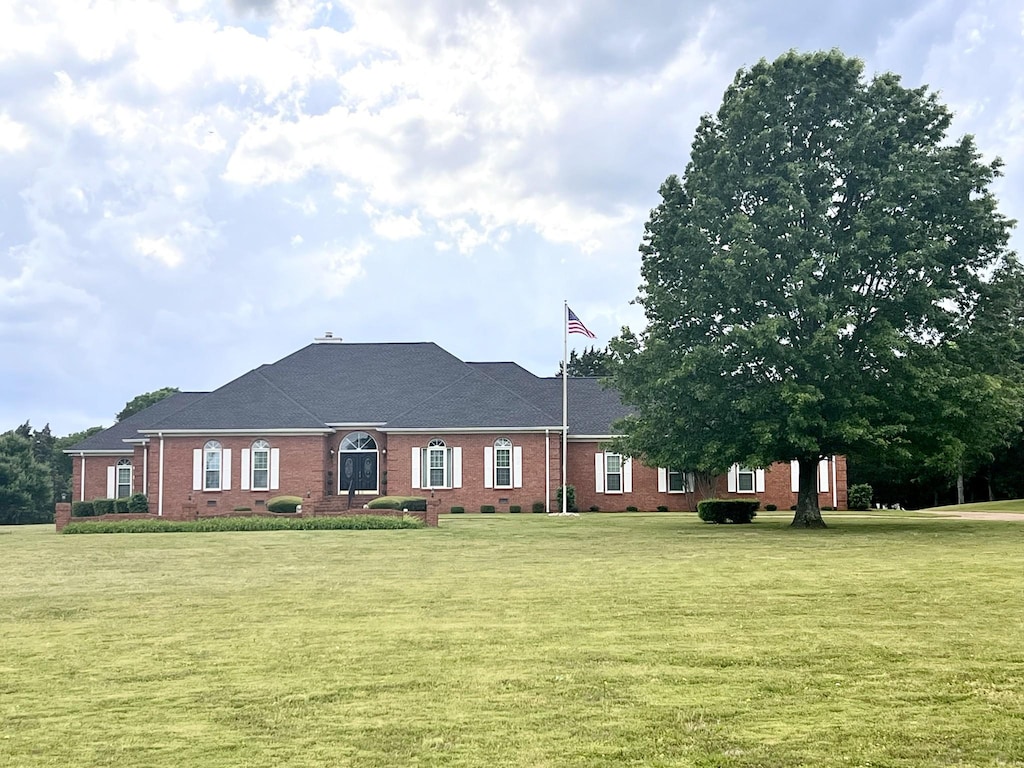 single story home featuring brick siding and a front yard