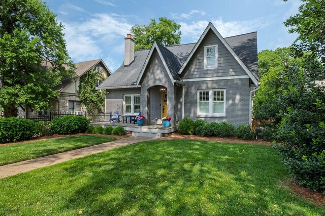2004 Natchez Trce, Nashville, TN 37212 - tudor-style house with covered porch, a chimney, a front yard, brick siding, and fence