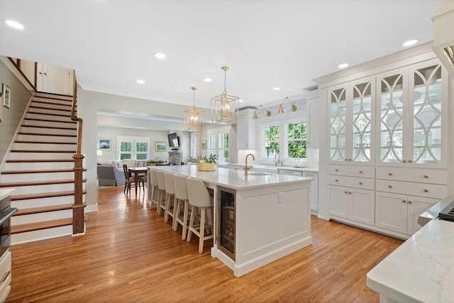 2004 Natchez Trce, Nashville, TN 37212 - kitchen featuring light wood-type flooring, a sink, white cabinetry, and an island with sink