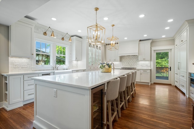 2004 Natchez Trce, Nashville, TN 37212 - kitchen featuring wine cooler, light countertops, custom range hood, backsplash, and a notable chandelier