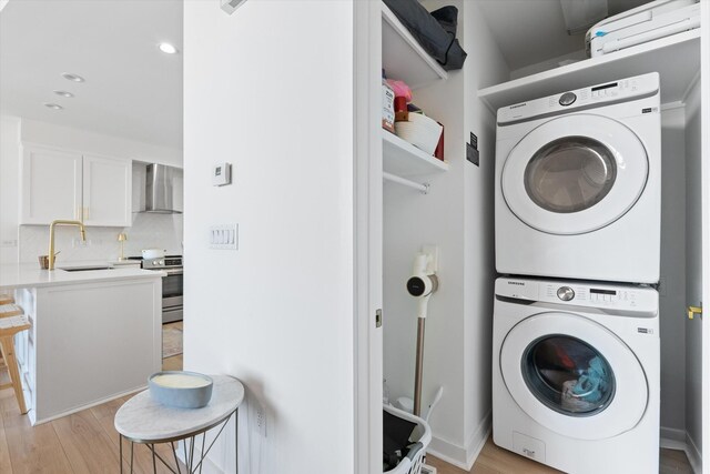 1510 Demonbreun St Unit 807, Nashville, TN 37203 - laundry area with laundry area, stacked washer / dryer, recessed lighting, a sink, and light wood-style flooring