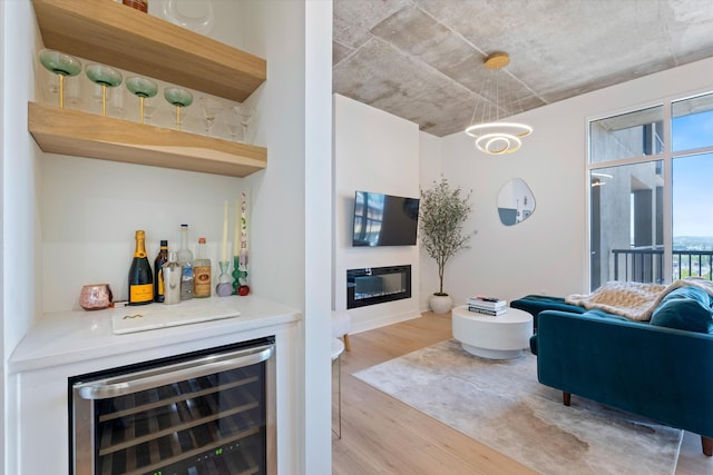 1510 Demonbreun St Unit 807, Nashville, TN 37203 - interior space with light wood-style floors, an inviting chandelier, a bar, a glass covered fireplace, and wine cooler