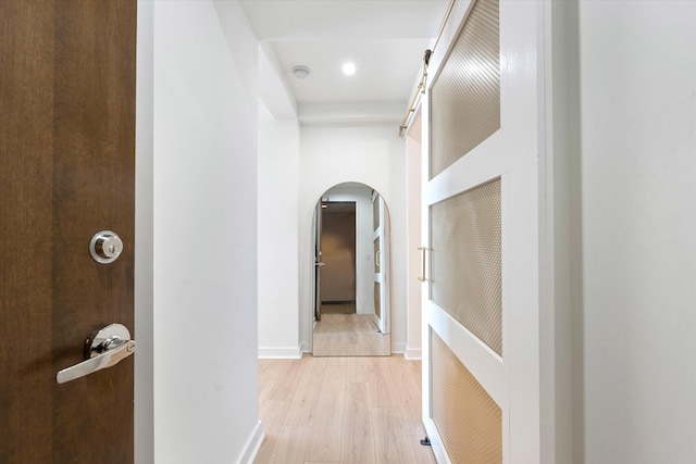 1510 Demonbreun St Unit 807, Nashville, TN 37203 - hall with arched walkways, baseboards, and light wood-style flooring