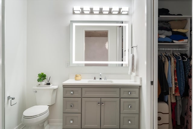 1510 Demonbreun St Unit 807, Nashville, TN 37203 - bathroom with vanity, baseboards, a walk in closet, and toilet