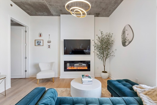1510 Demonbreun St Unit 807, Nashville, TN 37203 - living area featuring baseboards, a chandelier, a glass covered fireplace, and wood finished floors