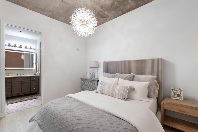 1510 Demonbreun St Unit 807, Nashville, TN 37203 - bedroom featuring an inviting chandelier, light wood-type flooring, a sink, and ensuite bath