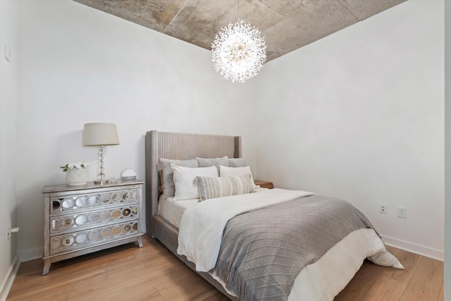 1510 Demonbreun St Unit 807, Nashville, TN 37203 - bedroom featuring baseboards, wood finished floors, and a chandelier