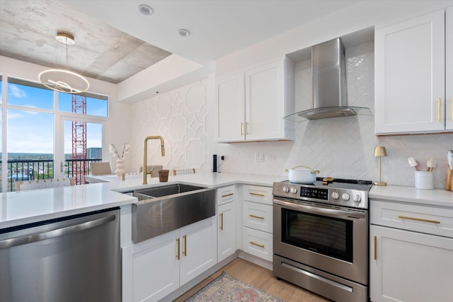 1510 Demonbreun St Unit 807, Nashville, TN 37203 - kitchen with wall chimney range hood, appliances with stainless steel finishes, a sink, and light countertops