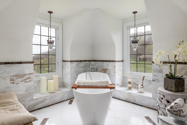 interior space featuring tile walls, plenty of natural light, and a chandelier
