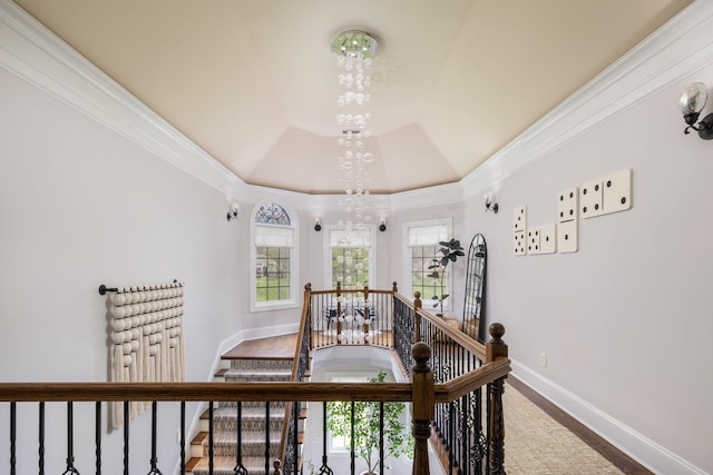 interior space featuring an inviting chandelier, baseboards, crown molding, and a tray ceiling