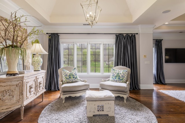 living area with baseboards, ornamental molding, wood finished floors, and a tray ceiling